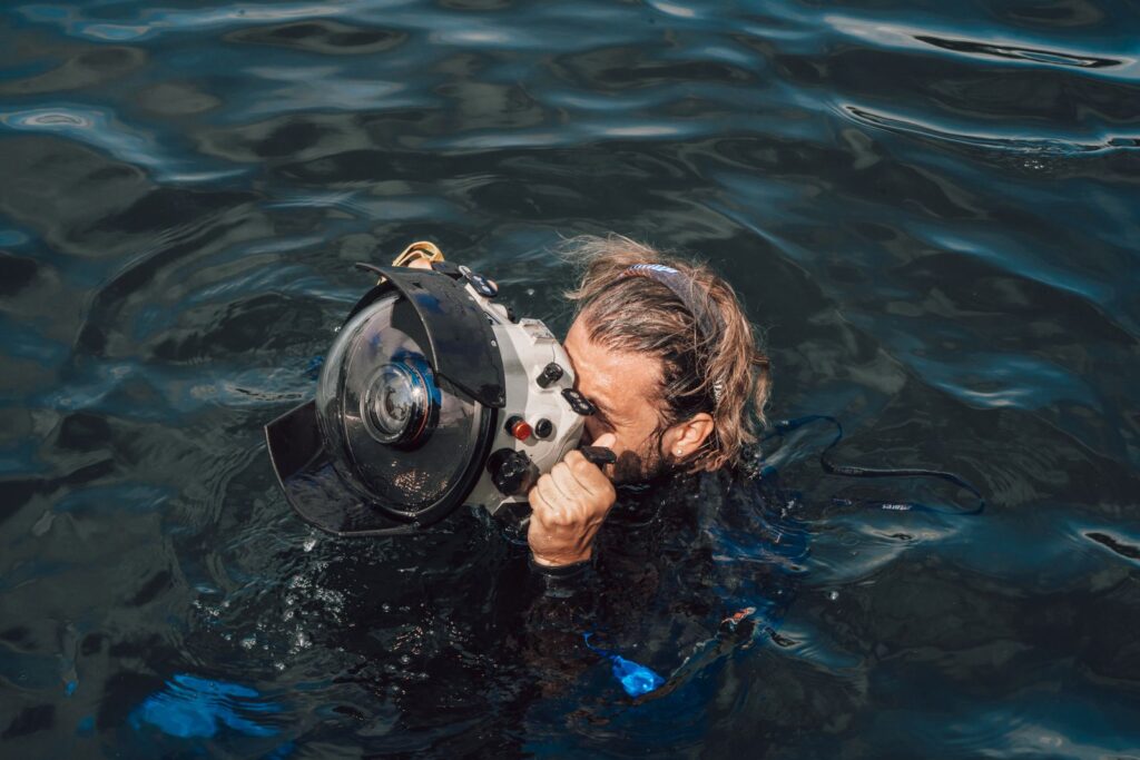Photographer using an underwater camera housing with dome port